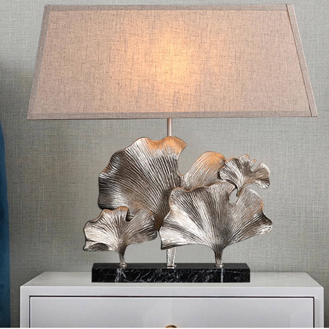 Серия настольных ламп с трапециевидным текстильным абажуром и декором в виде хромированных листьев гинкго на мраморном основании PHILOMENA L75