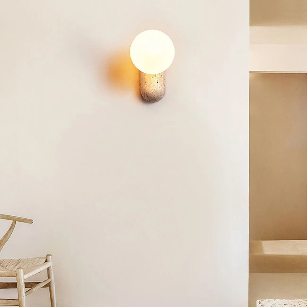 Настенный светильник с шарообразным стеклянным плафоном на округлом основании из камня травертина JONTE