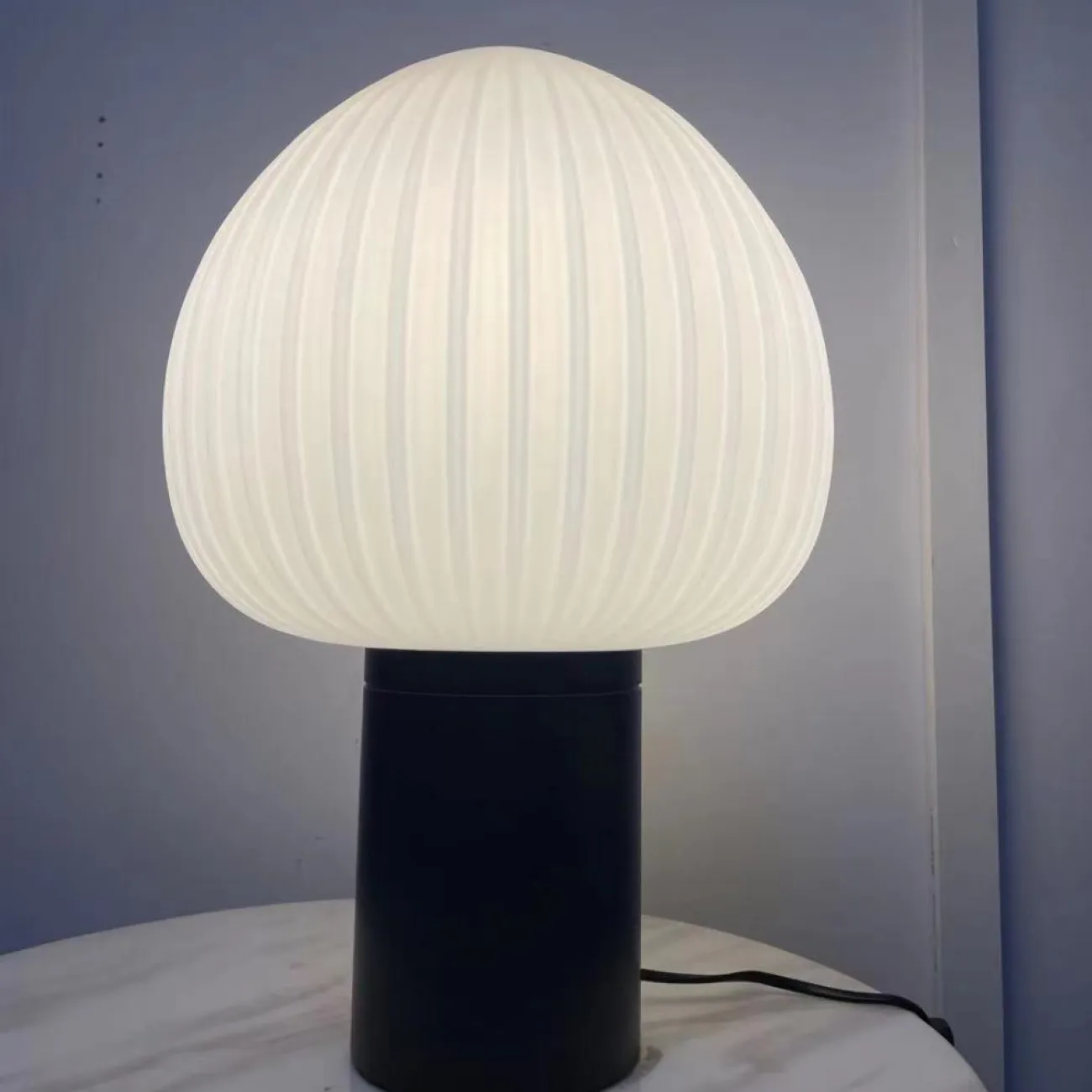 Настольная лампа с округлым плафоном из белого рельефного стекла на черном цилиндрическом основании VICCI Настольная лампа с округлым плафоном из белого рельефного стекла на черном цилиндрическом основании VICCI