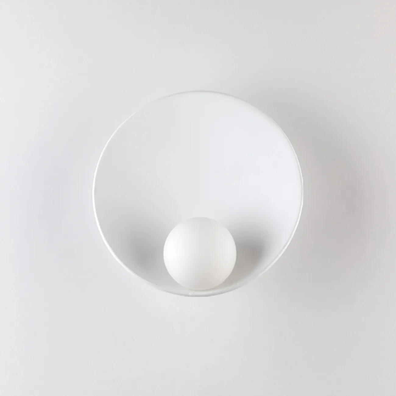Дизайнерский настенный светильник с матовым шарообразным плафоном из стекла на белом дисковидном основании SESSEL
