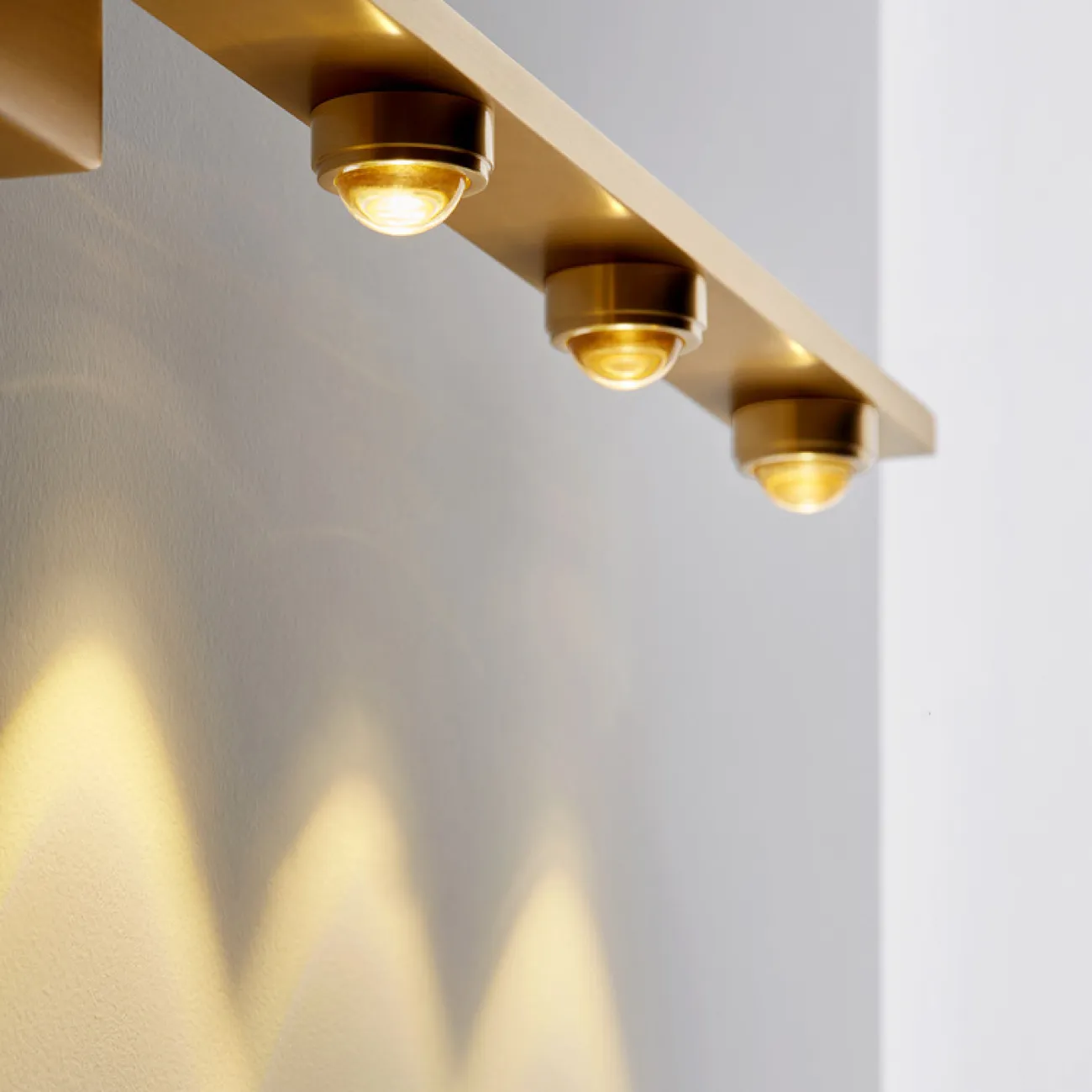 Серия настенных светильников с тремя линзированными светодиодными источниками на горизонтальной рейке ELENORA B Brass