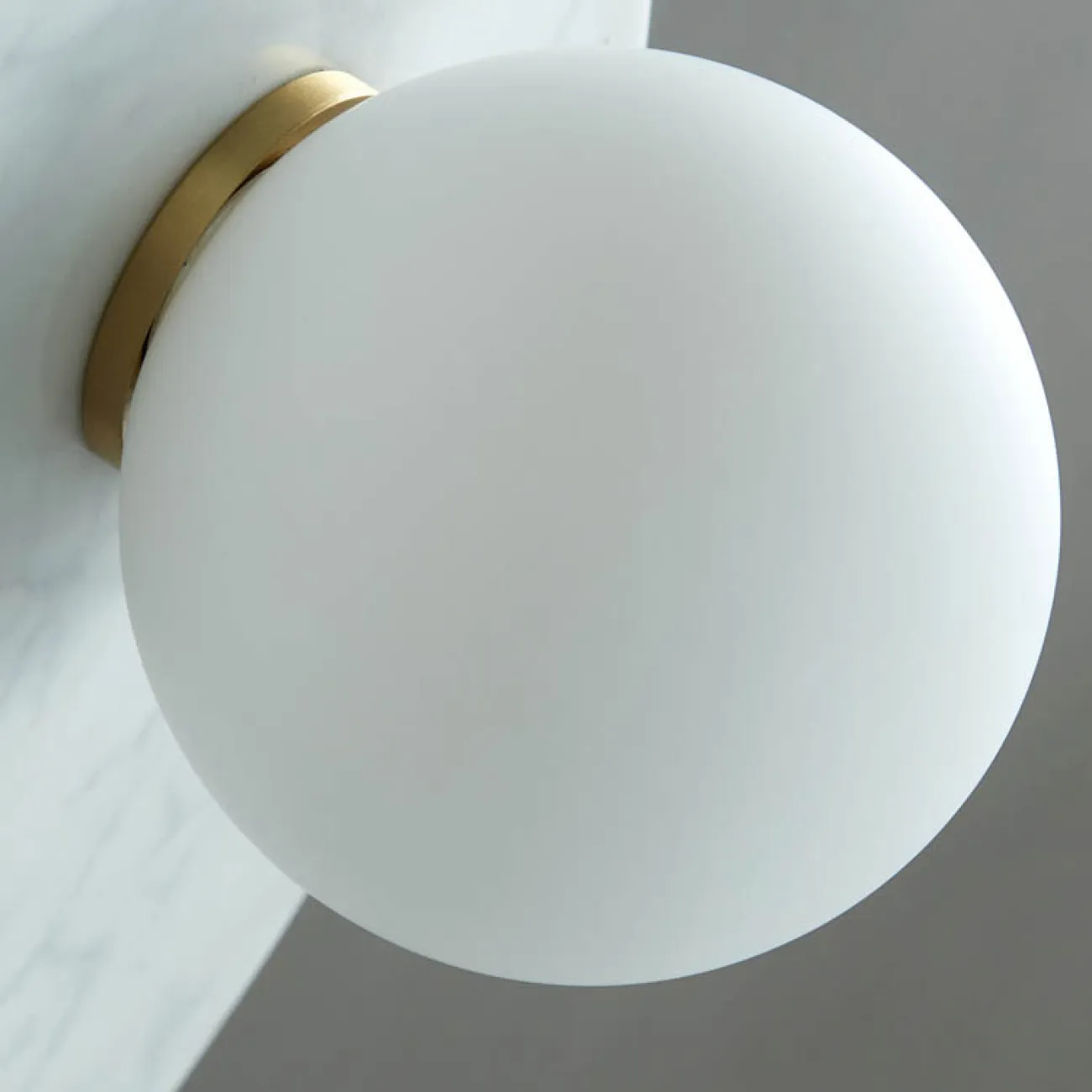 Серия настенных светильников с белым шарообразным плафоном из стекла на мраморном основании со скругленными краями FIORI White